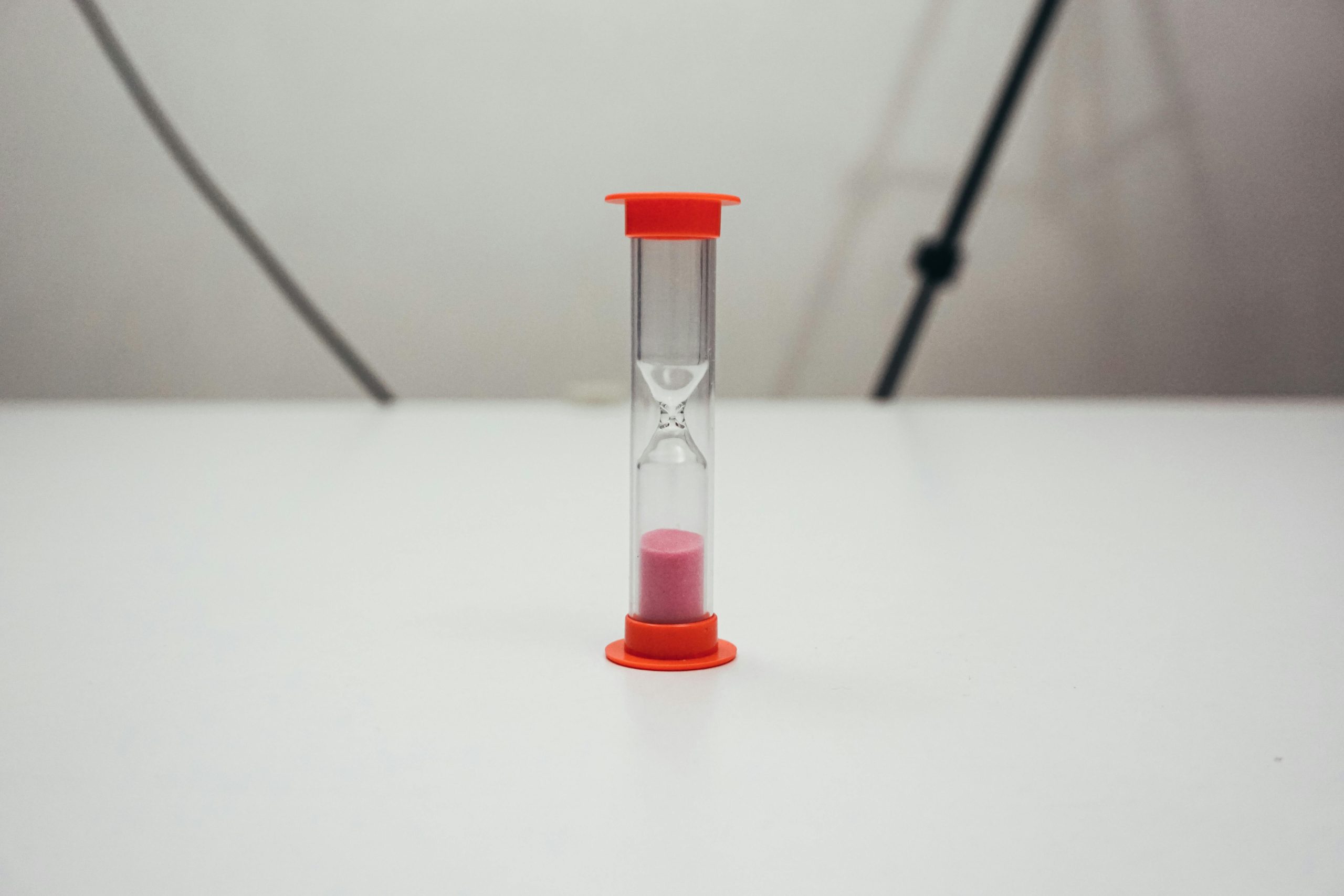A small red hourglass sitting on a table